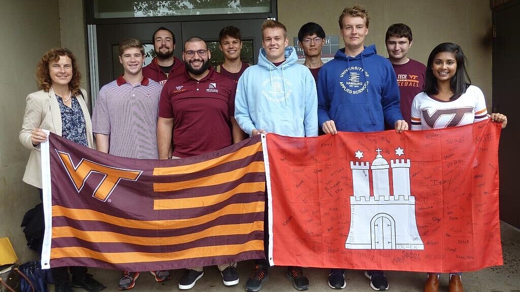 Group of students with professor holding university flags