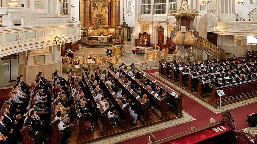 Am 17. Juni verabschiedet das Department Maschinenbau und Produktion seine Absolvent*innen der Jahrgänge 2020/21 sowie 2021/22 in der evangelischen Hauptkirche Sankt Michaelis. Blick von oben auf die Absolvent*innen in der Kirche Sankt Michaelis