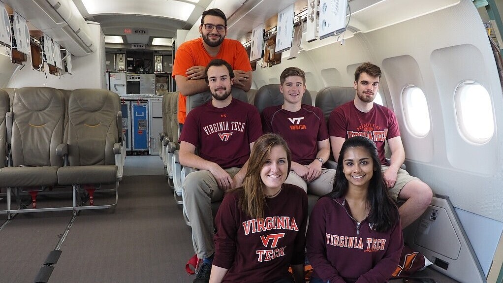 Male and female students sitting in an aircraft cabin