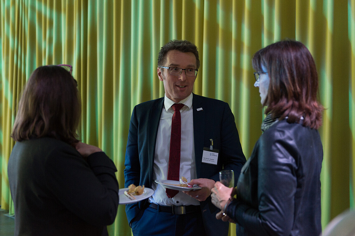 Auf der Vergabefeier unterhalten sich der Hochschulpräsident, Prof. Dr. Micha Teuscher und zwei Professorinnen der Hochschule