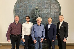 
                Aktuelle Mitarbeiter des TREC - 4 wissenschaftkiche Mitarbeiter und ihr Professor vor historischem Brunnen der Eingangshalle im Berliner Tor 21 
            