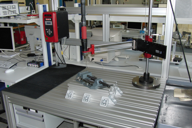 Arbeitstisch aus massiven Aluminiumprofilen mit variabel montierbaren Schraubstöcken, zur Fixierung von Bauteilen die versuchsweise mit einer elektronischen Schraubspindel verschraubt werden.